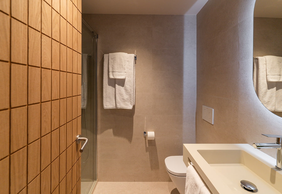 Baño con lavabo, ducha, amenities y toallas