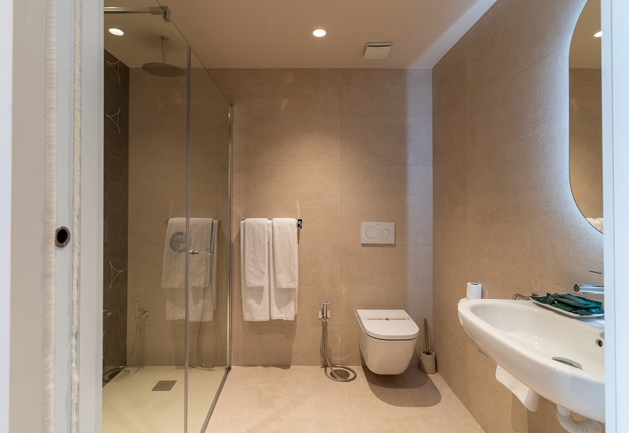 Baño con plato de ducha, wc, lavabo grande y espejo retroiluminado